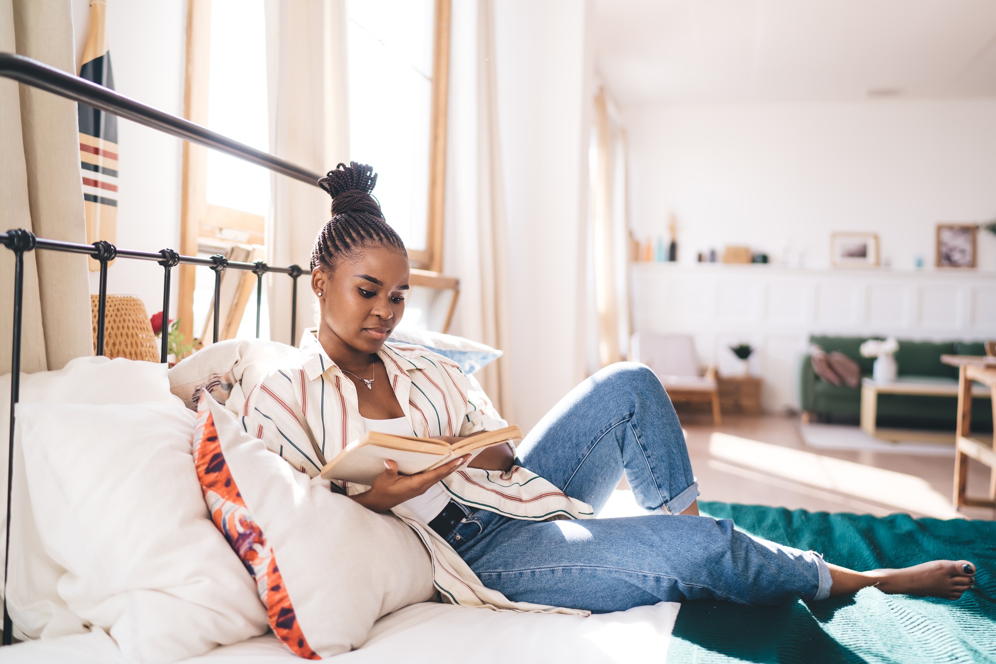 Calm black woman reading interesting story on bed